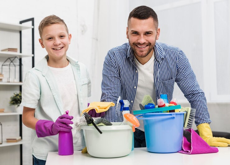 front-view-smiley-father-son-posing-with-cleaning-products_23-2148457029